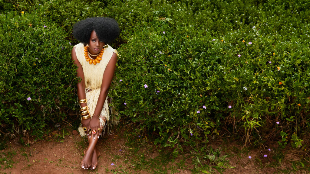 a woman sitting in the grass facing toward the sky
