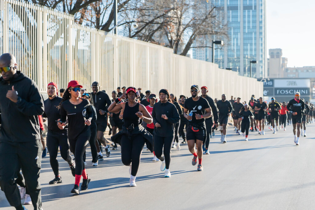 People running in the streets next to tall buildings