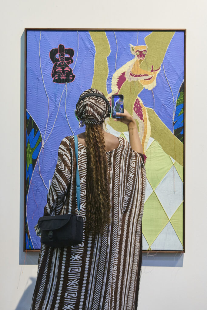 A woman takes a picture of a artwork