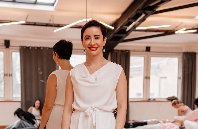 A woman wearing a white jump suit in a studio