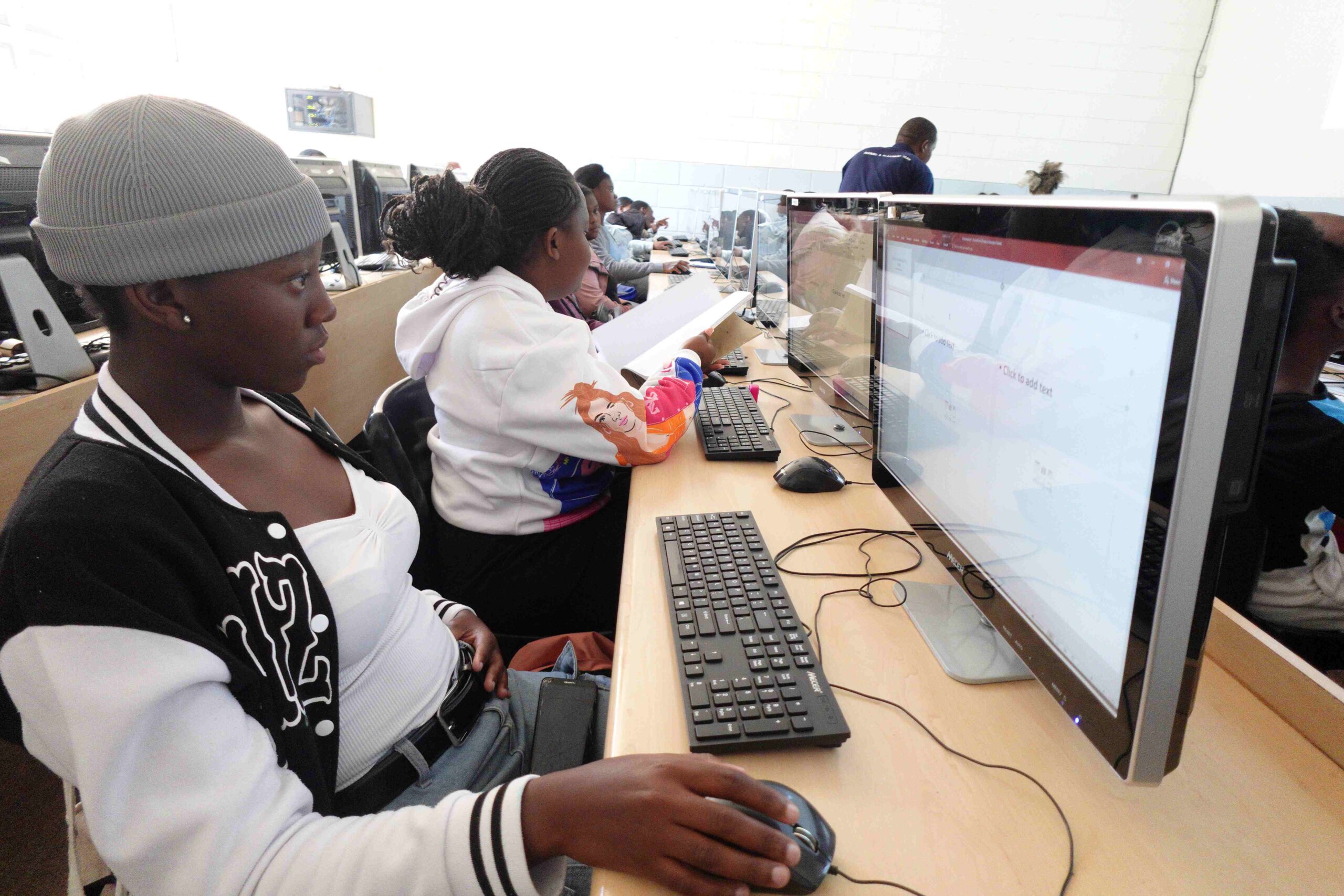 young children sit behind computers in a computer lab