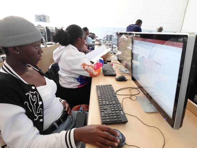 young children sit behind computers in a computer lab