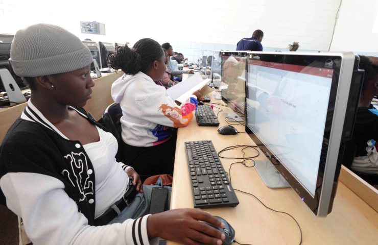 young children sit behind computers in a computer lab